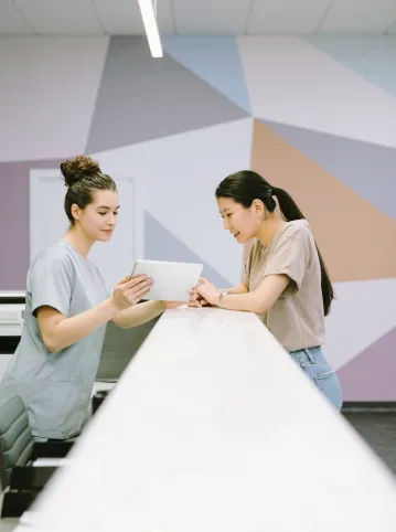 A clinic staff showing a client information on a tablet